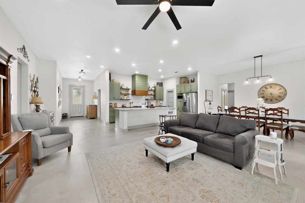 a living room with lots of furniture and view of kitchen