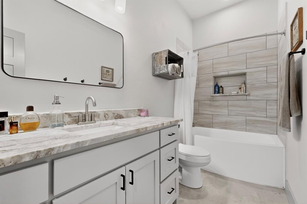 613 Kentucky Town Road Whitewright, TX 75491 - Photo 15 of 39 a bathroom with a granite countertop sink a toilet and mirror