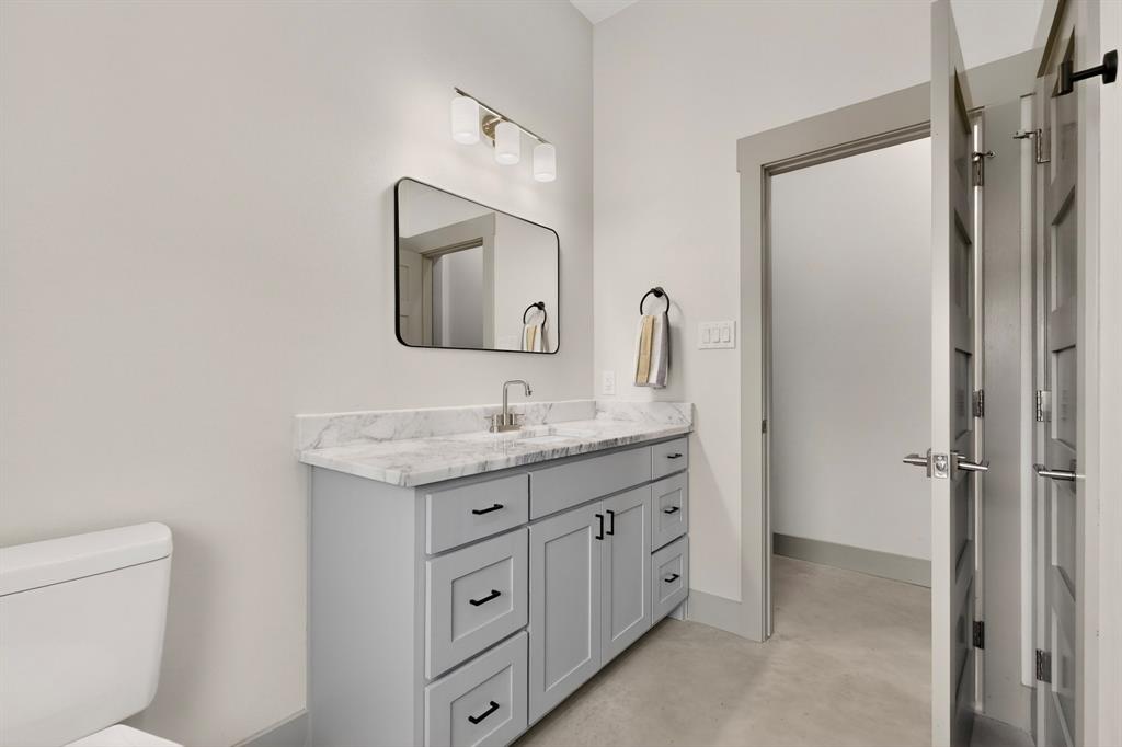 613 Kentucky Town Road Whitewright, TX 75491 - Photo 24 of 39 a bathroom with a granite countertop sink vanity mirror and toilet