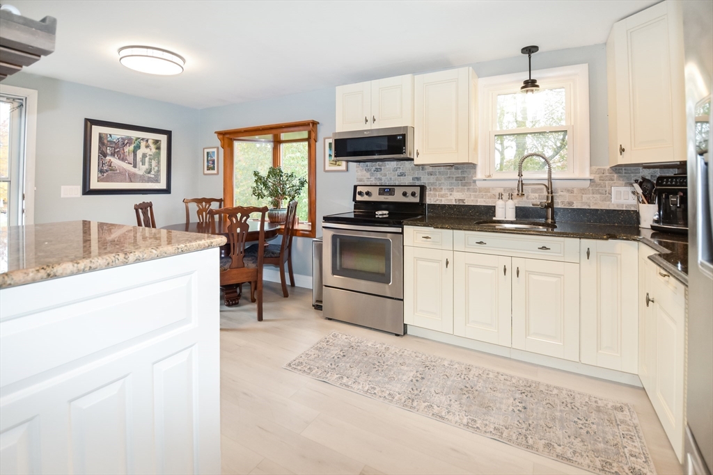360 High Street Whitman, MA 02382 - Photo 5 of 33 a kitchen with granite countertop a sink stainless steel appliances and white cabinets