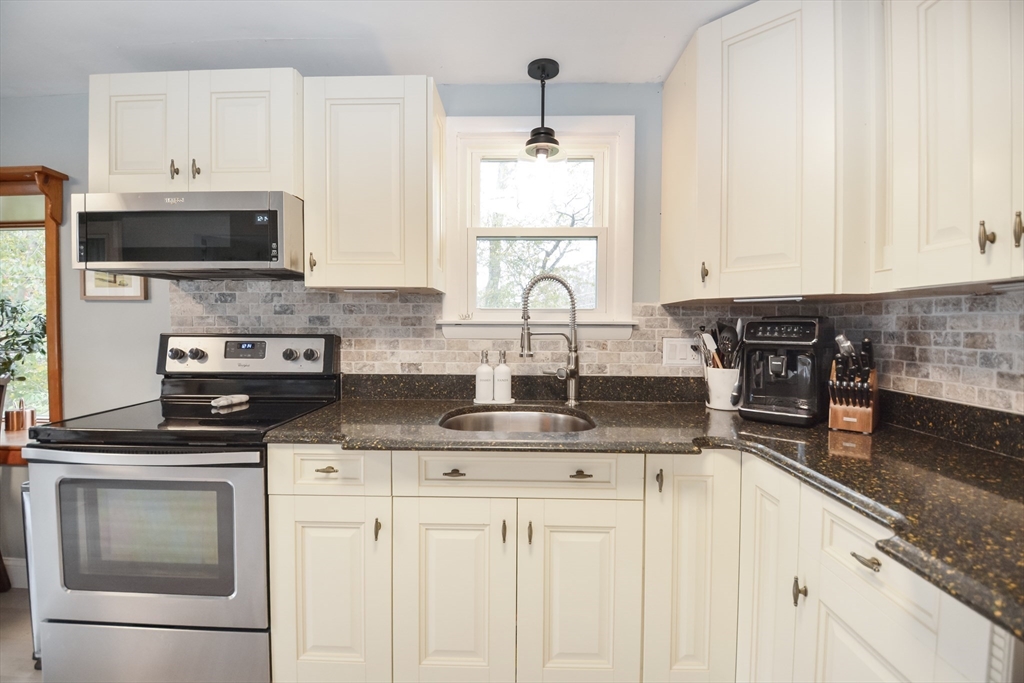 360 High Street Whitman, MA 02382 - Photo 6 of 33 a kitchen with stainless steel appliances granite countertop a sink a stove a microwave and wooden cabinets