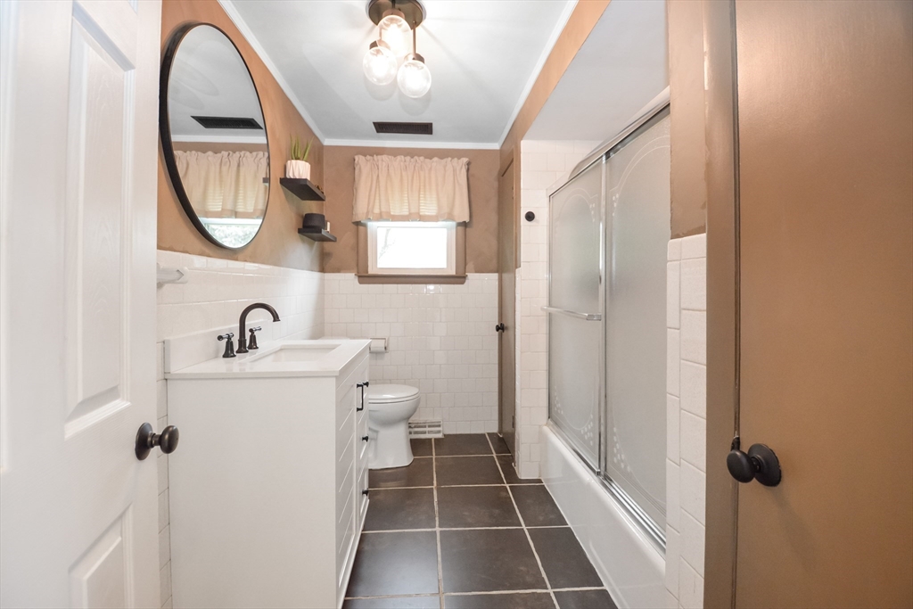 360 High Street Whitman, MA 02382 - Photo 9 of 33 a bathroom with a toilet a sink and a mirror