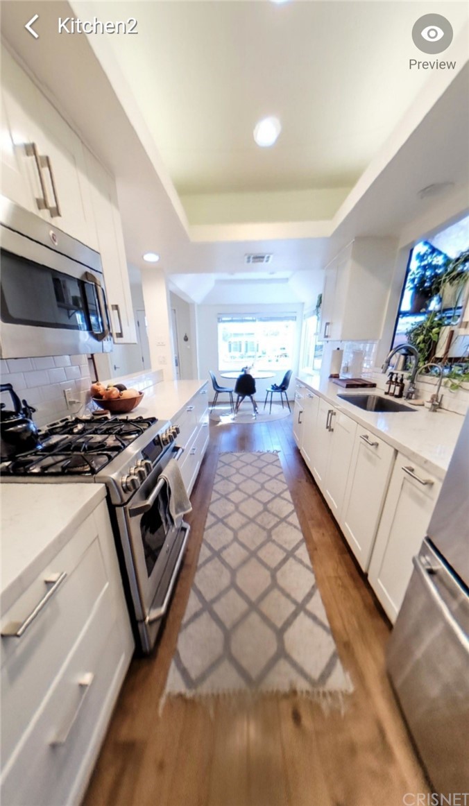 14721 Weddington Street Sherman Oaks, CA 91411 - Photo 9 of 17 a kitchen with stainless steel appliances a sink a stove and a table