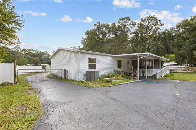 a view of a house with backyard and sitting area