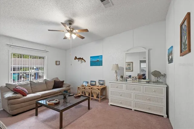 a living room with furniture a ceiling fan and a window