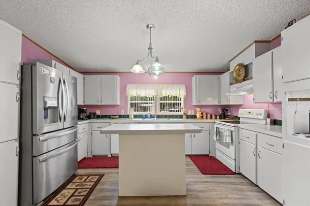 a kitchen with granite countertop a sink stainless steel appliances and window