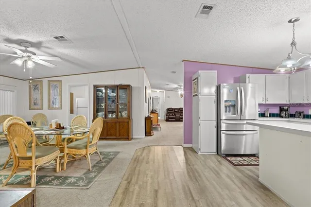 a kitchen with stainless steel appliances kitchen island granite countertop a refrigerator and microwave