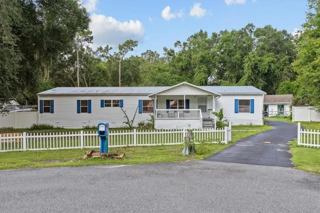 a front view of a house with a garden and plants
