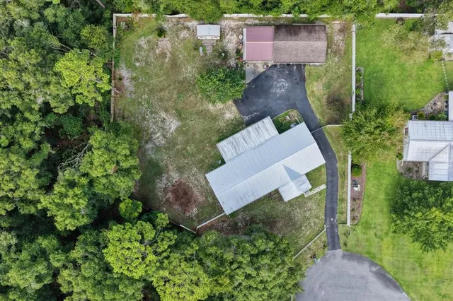 an aerial view of a house with a yard and lake view