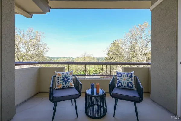 a balcony with furniture and a potted plant