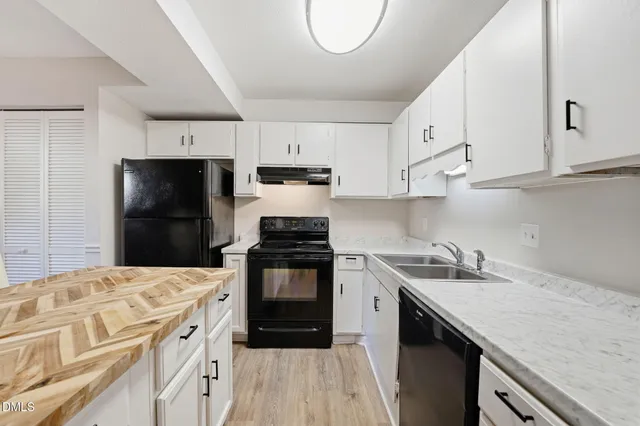 a kitchen with a sink a stove a refrigerator and cabinets