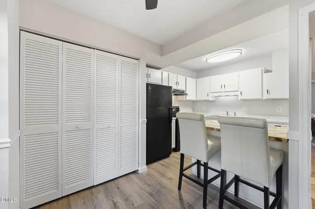 a kitchen with a refrigerator and white cabinets
