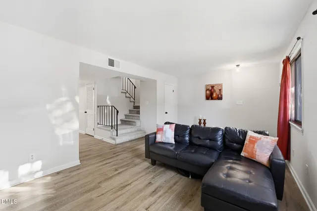 a living room with furniture and a wooden floor