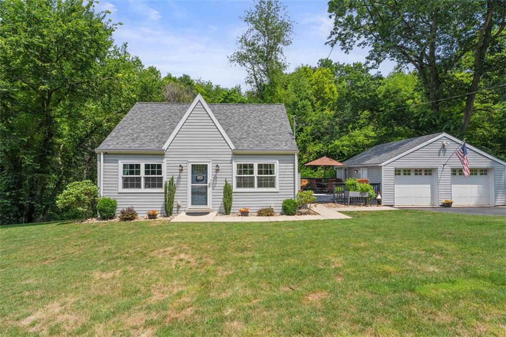a front view of a house with a yard and trees