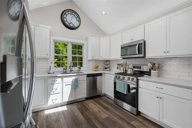 a kitchen with stainless steel appliances granite countertop a stove a sink and a refrigerator