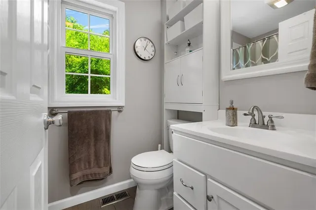 a bathroom with a toilet a sink and a window