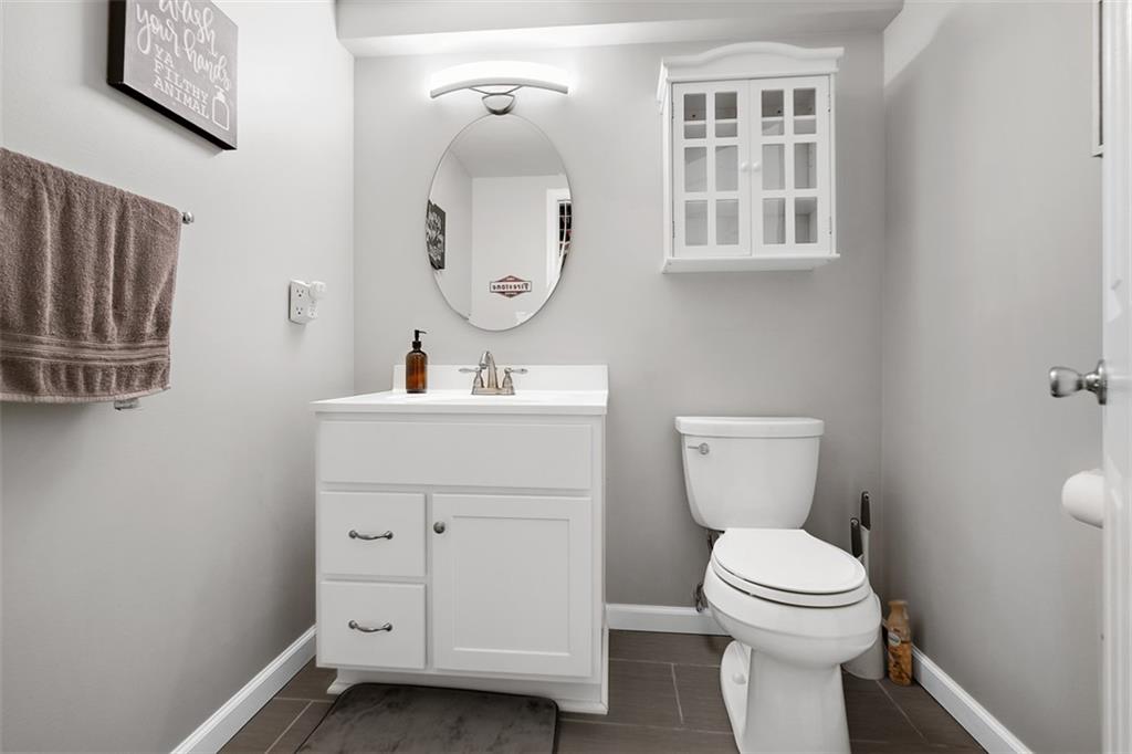 505 Center Grange Road Monaca, PA 15061 - Photo 32 of 43 a bathroom with a toilet a sink a mirror a vanity and a window