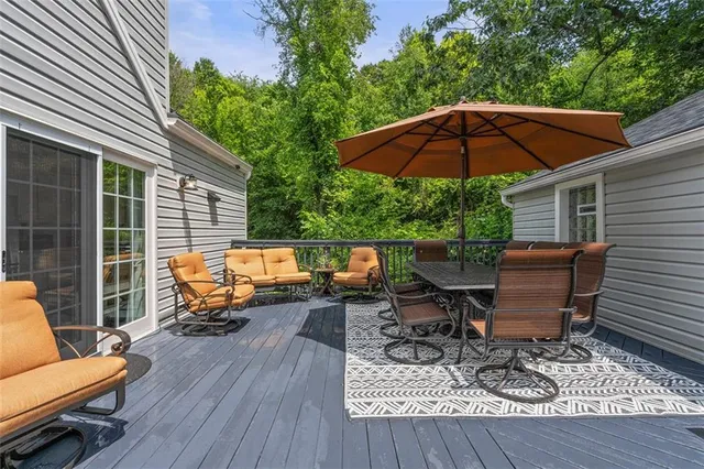 an outdoor sitting area with furniture and wooden deck