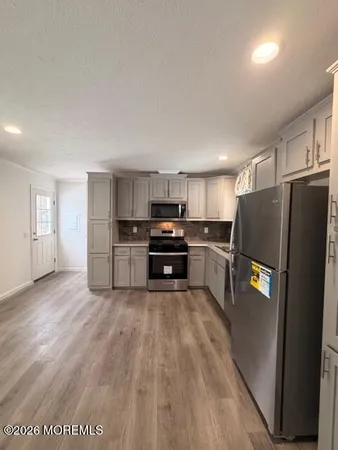 a kitchen with granite countertop a refrigerator and a stove top oven