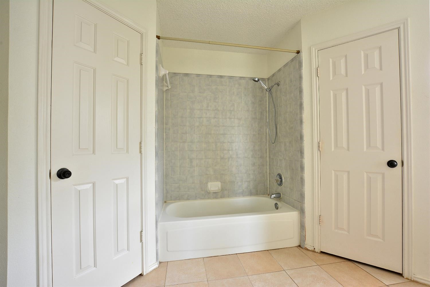 5917 71st Street Lubbock, TX 79424 - Photo 14 of 18 a bathroom with a bathtub and a shower