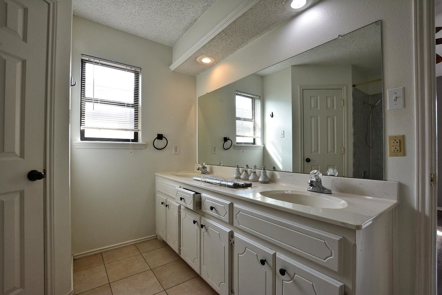 5917 71st Street Lubbock, TX 79424 - Photo 15 of 18 a bathroom with 2 sink and a mirror