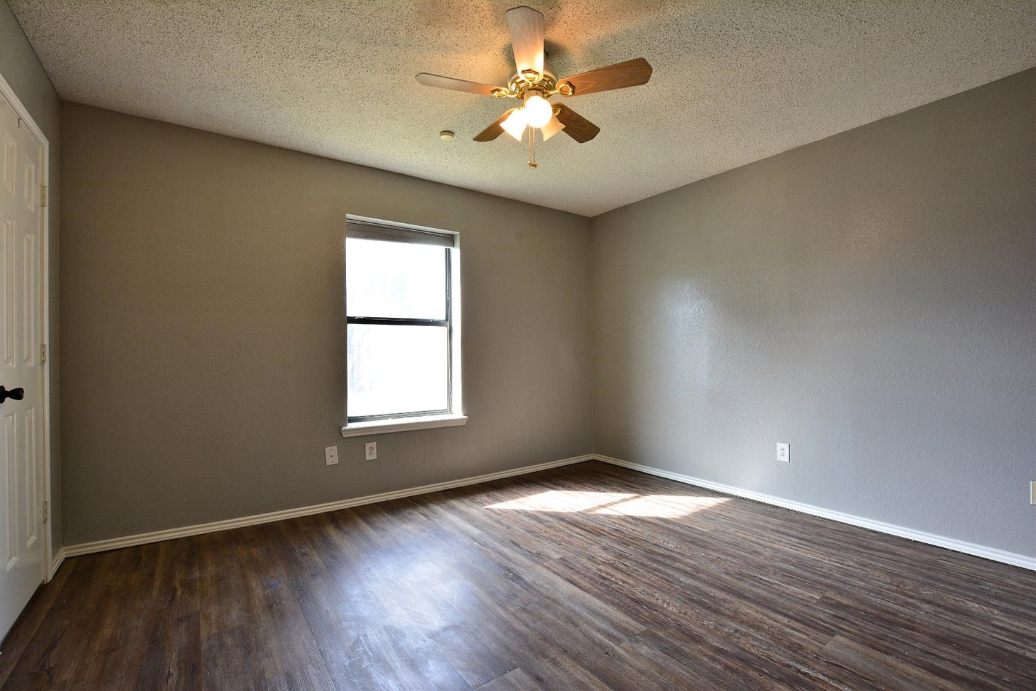 5917 71st Street Lubbock, TX 79424 - Photo 16 of 18 an empty room with wooden floor and windows