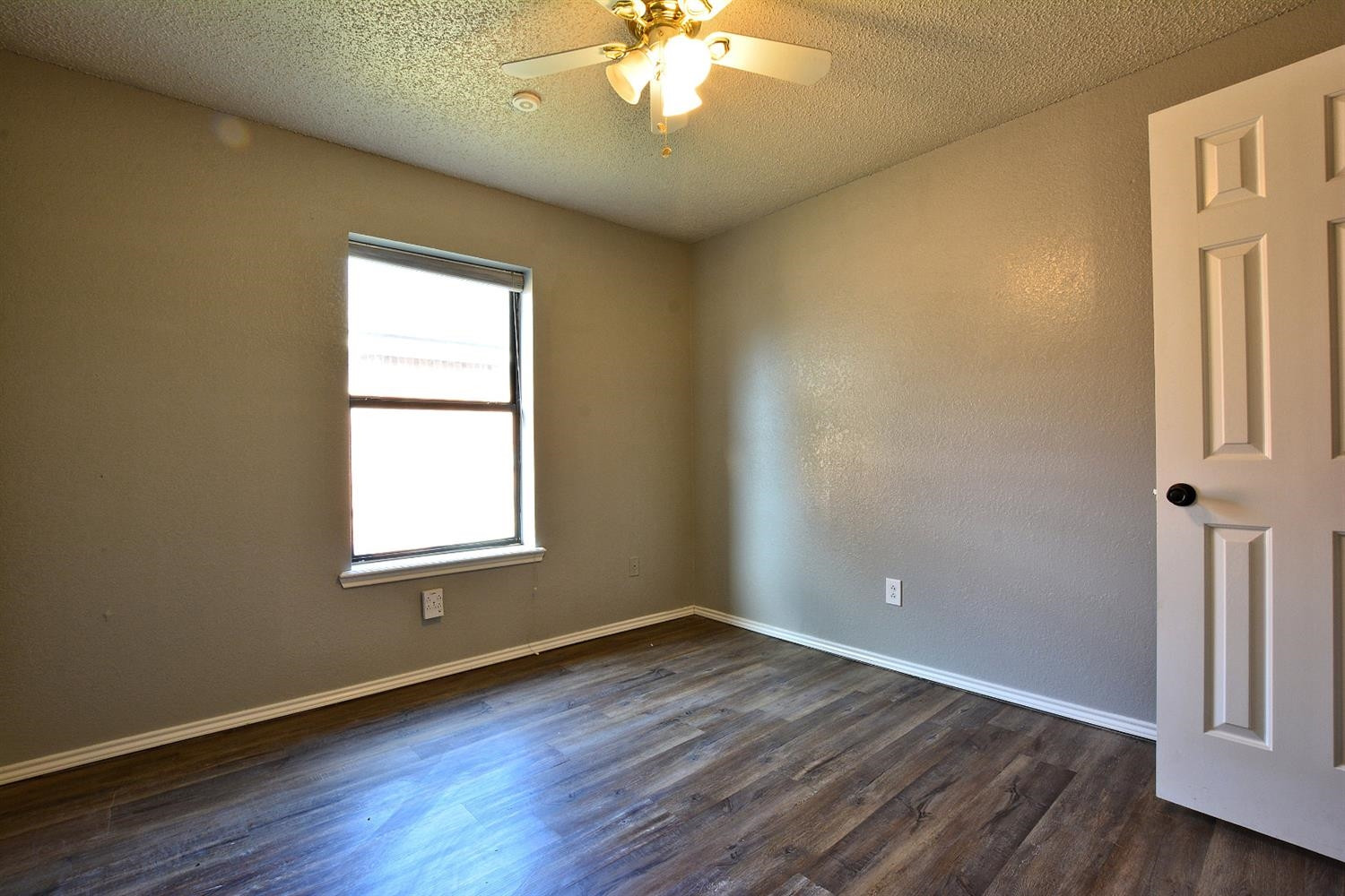 5917 71st Street Lubbock, TX 79424 - Photo 17 of 18 an empty room with wooden floor and windows