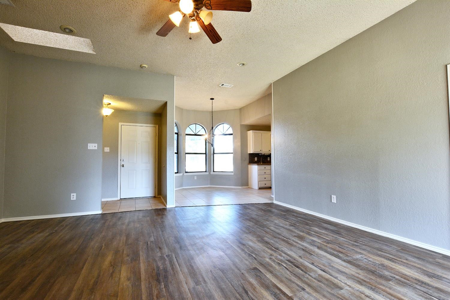 5917 71st Street Lubbock, TX 79424 - Photo 5 of 18 a view of empty room with wooden floor and fan