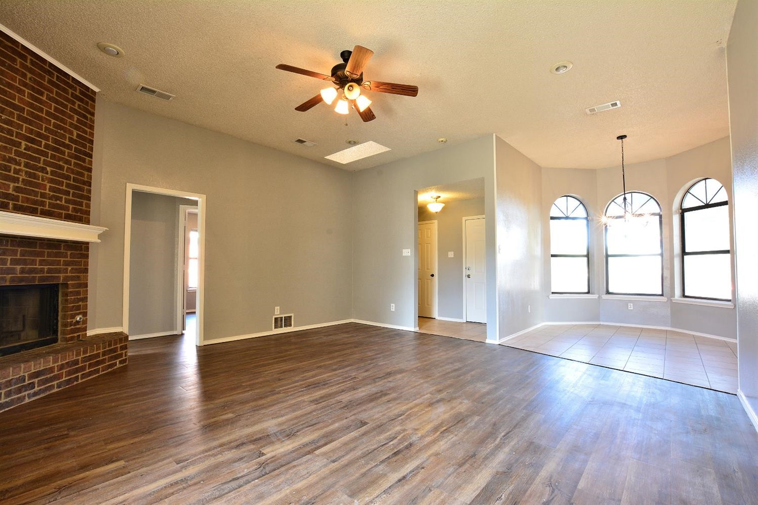 5917 71st Street Lubbock, TX 79424 - Photo 6 of 18 an empty room with wooden floor and chandelier fan