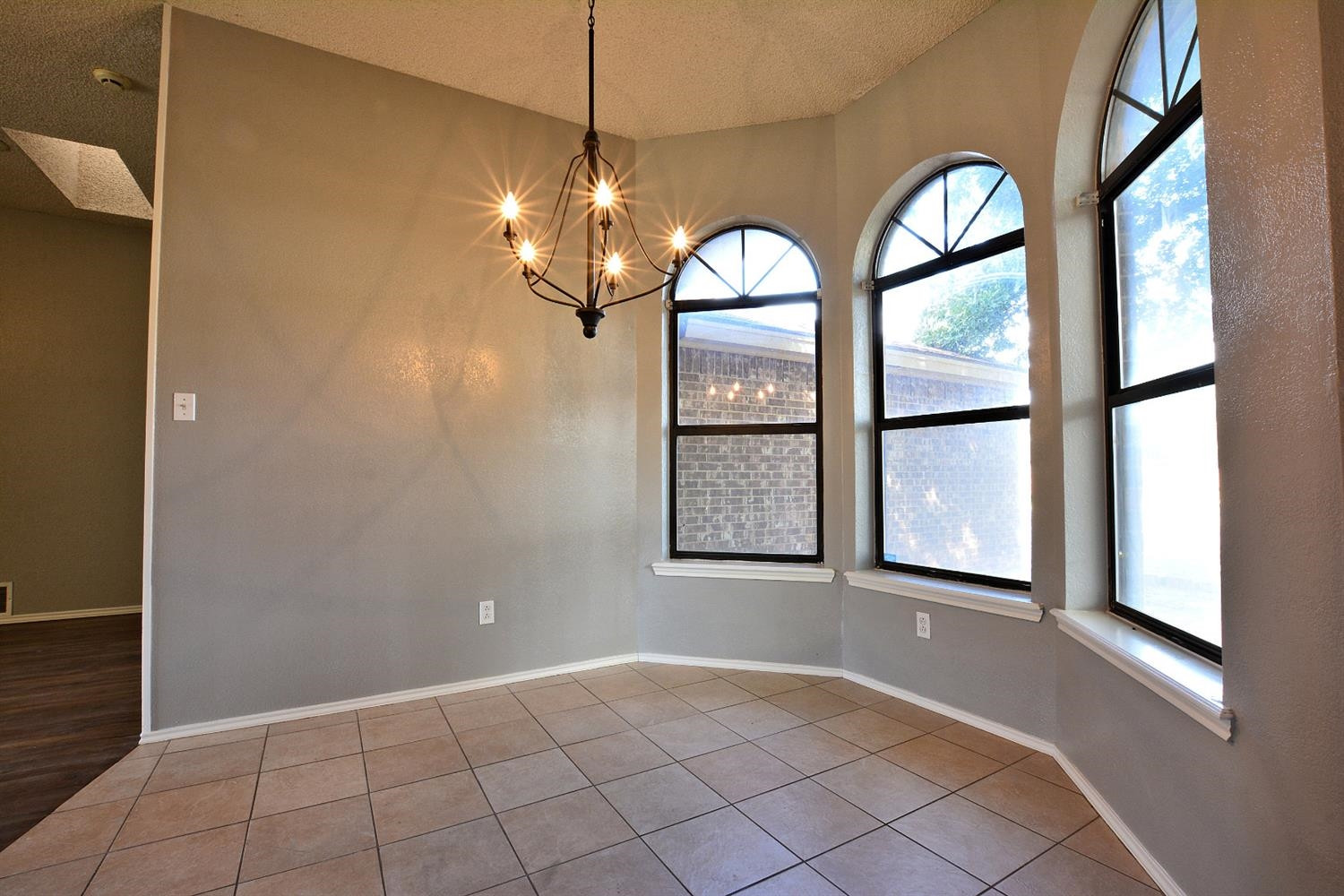 5917 71st Street Lubbock, TX 79424 - Photo 8 of 18 a view of an empty room with a window and chandelier