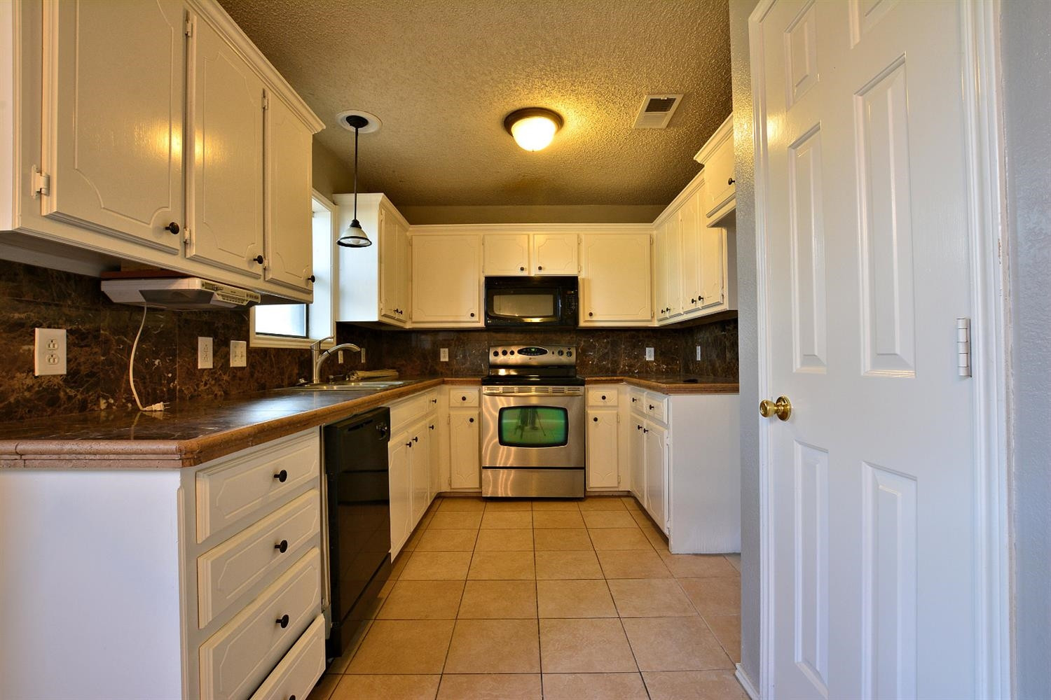 5917 71st Street Lubbock, TX 79424 - Photo 9 of 18 a kitchen with stainless steel appliances granite countertop a stove and a sink