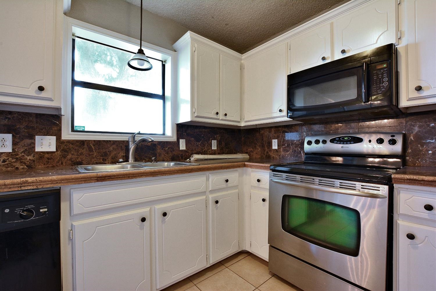 5917 71st Street Lubbock, TX 79424 - Photo 10 of 18 a kitchen with stainless steel appliances granite countertop a stove a microwave a sink and cabinets