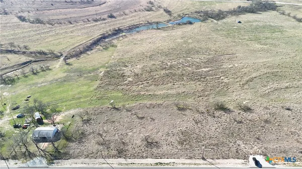 a view of a dry yard with wooden fence