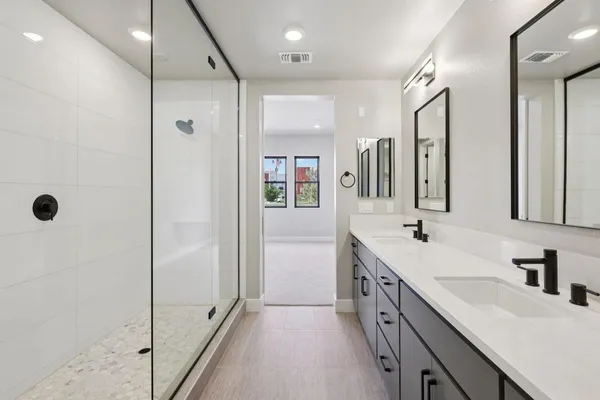 a bathroom with a double vanity sink a mirror and a shower