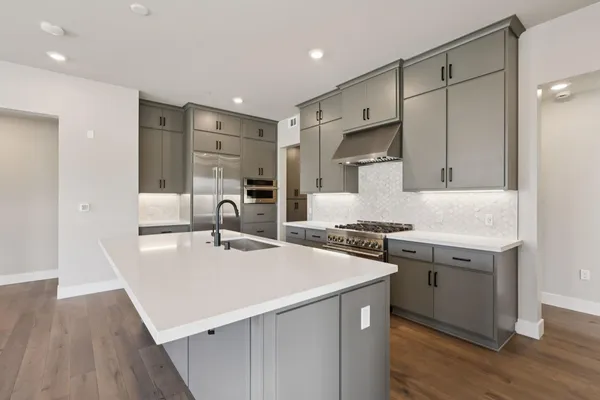 a kitchen with stainless steel appliances granite countertop a sink stove and refrigerator