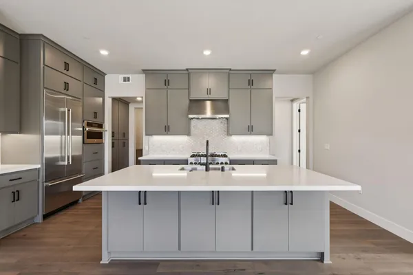 a kitchen with kitchen island a counter top space a sink stainless steel appliances and cabinets