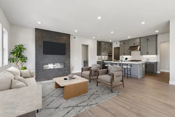 a living room with furniture kitchen view and a fireplace