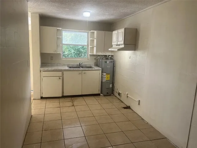 a kitchen with a sink a stove top oven and cabinets