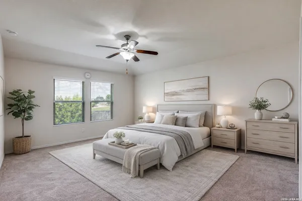 a bedroom with a large bed and a chandelier fan