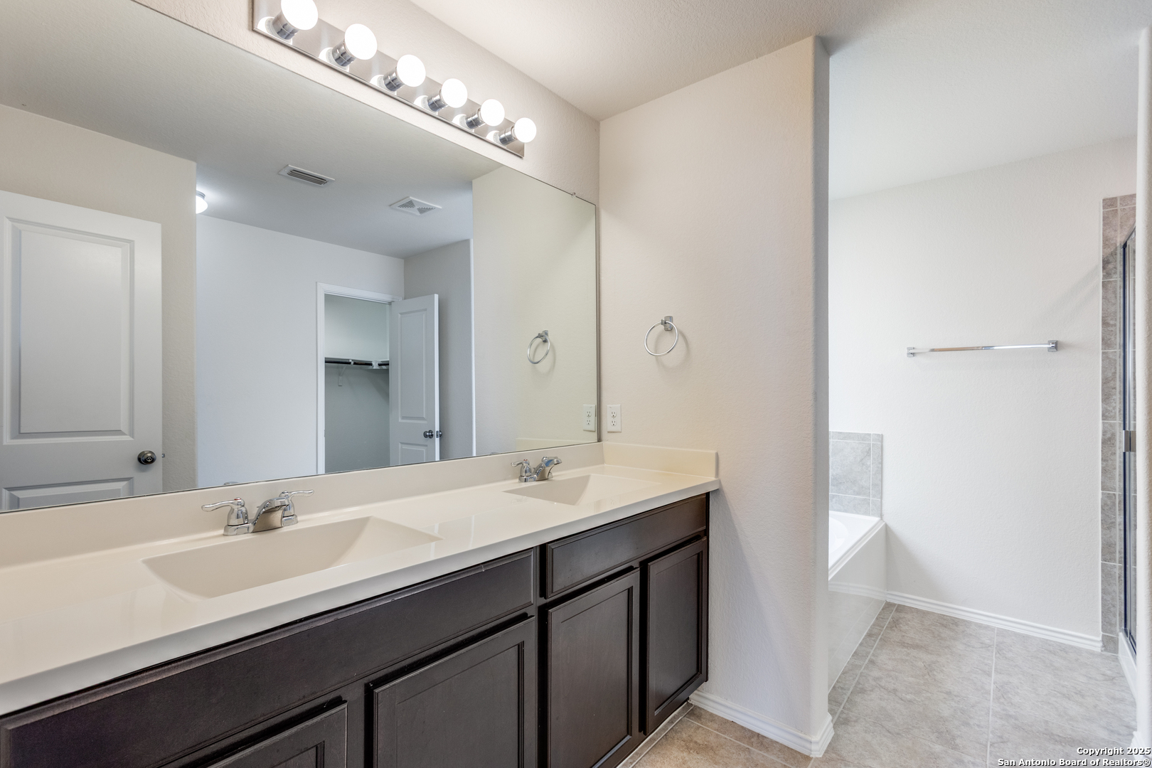 445 Red Morganite Trail Buda, TX 78610 - Photo 14 of 25 a bathroom with a double vanity sink and a mirror