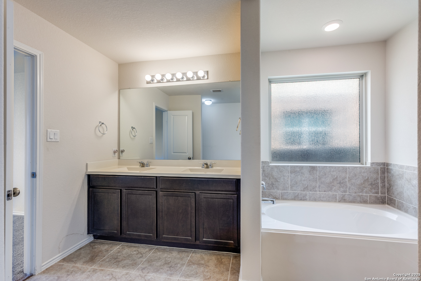 445 Red Morganite Trail Buda, TX 78610 - Photo 15 of 25 a spacious bathroom with a tub sink shower and mirror