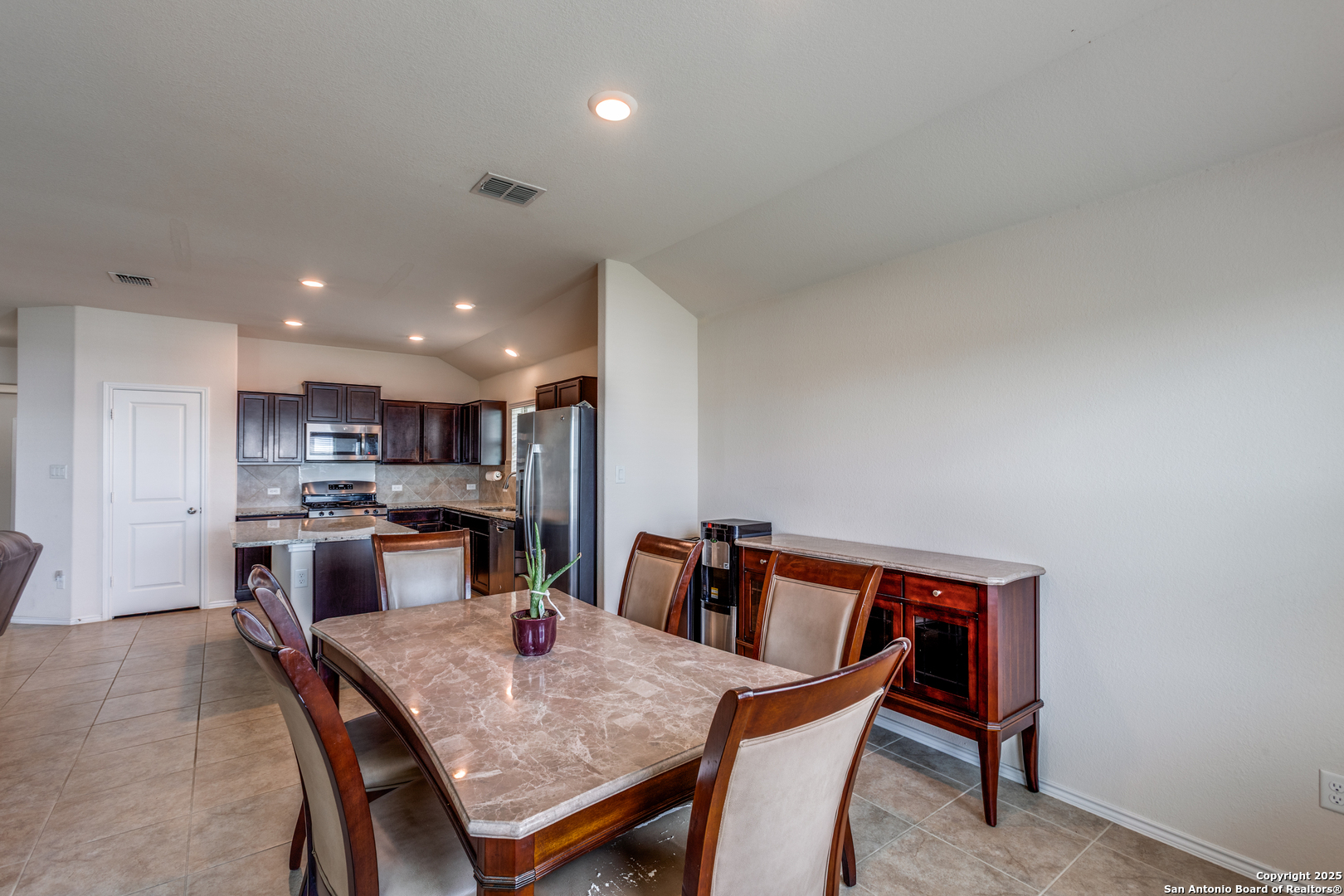 445 Red Morganite Trail Buda, TX 78610 - Photo 5 of 25 a kitchen with kitchen island a dining table and chairs