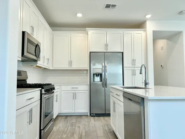 a kitchen with white cabinets and stainless steel appliances