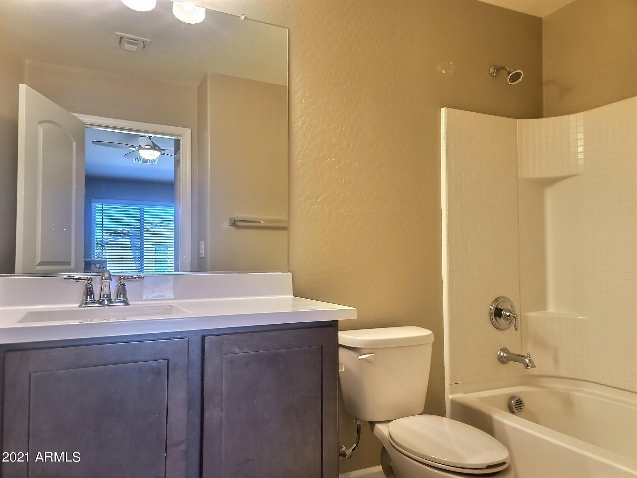 240 West Juniper Avenue, Unit 1111 Gilbert, AZ 85233 - Photo 11 of 22 a bathroom with a sink a toilet and shower