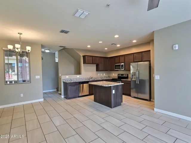 a large kitchen with a large counter top stainless steel appliances and cabinets