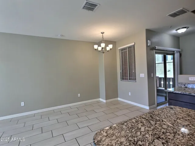 a view of a livingroom with a chandelier fan and windows