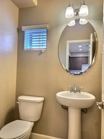a bathroom with a toilet sink and mirror