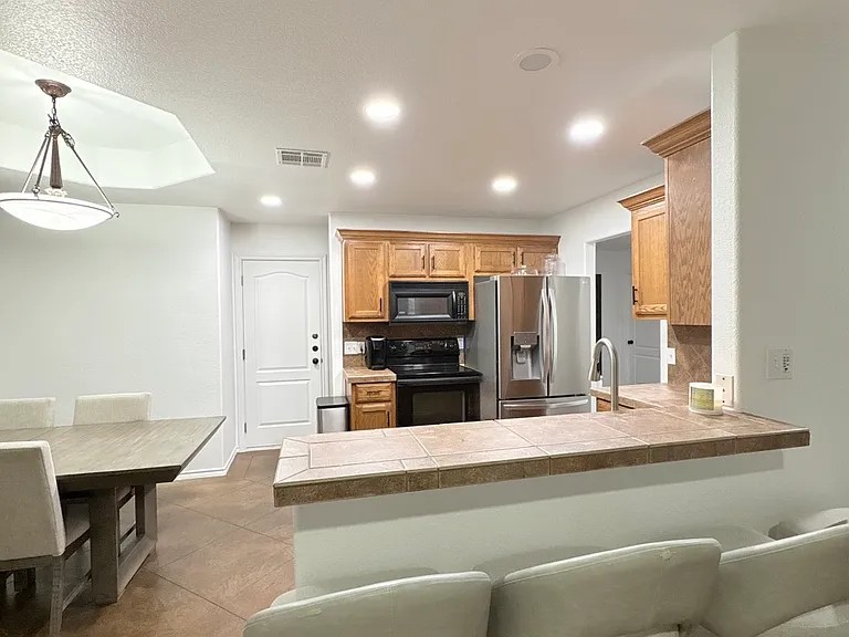 430 Summit Ridge Drive North Point Venture, TX 78645 - Photo 7 of 26 Functional kitchen with warm wood cabinetry seamlessly connects to a relaxed dining area.