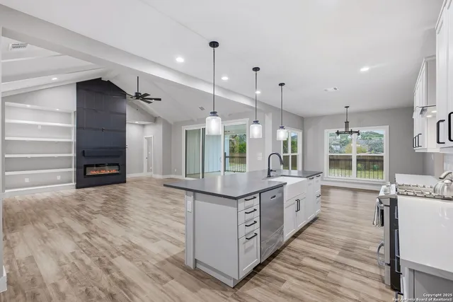 a large kitchen with kitchen island a stove a sink dishwasher and a oven with cabinets