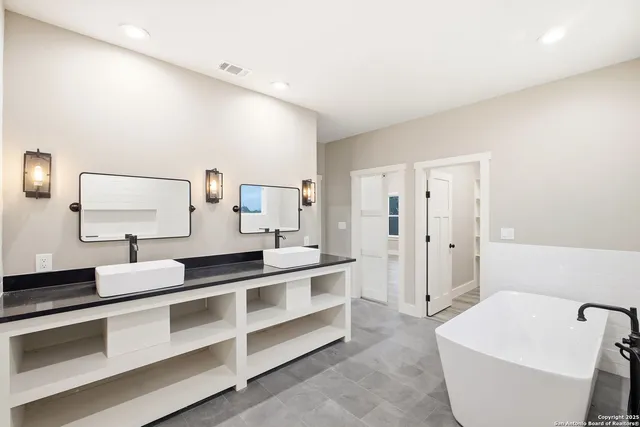 a large white room with a large mirror and sink